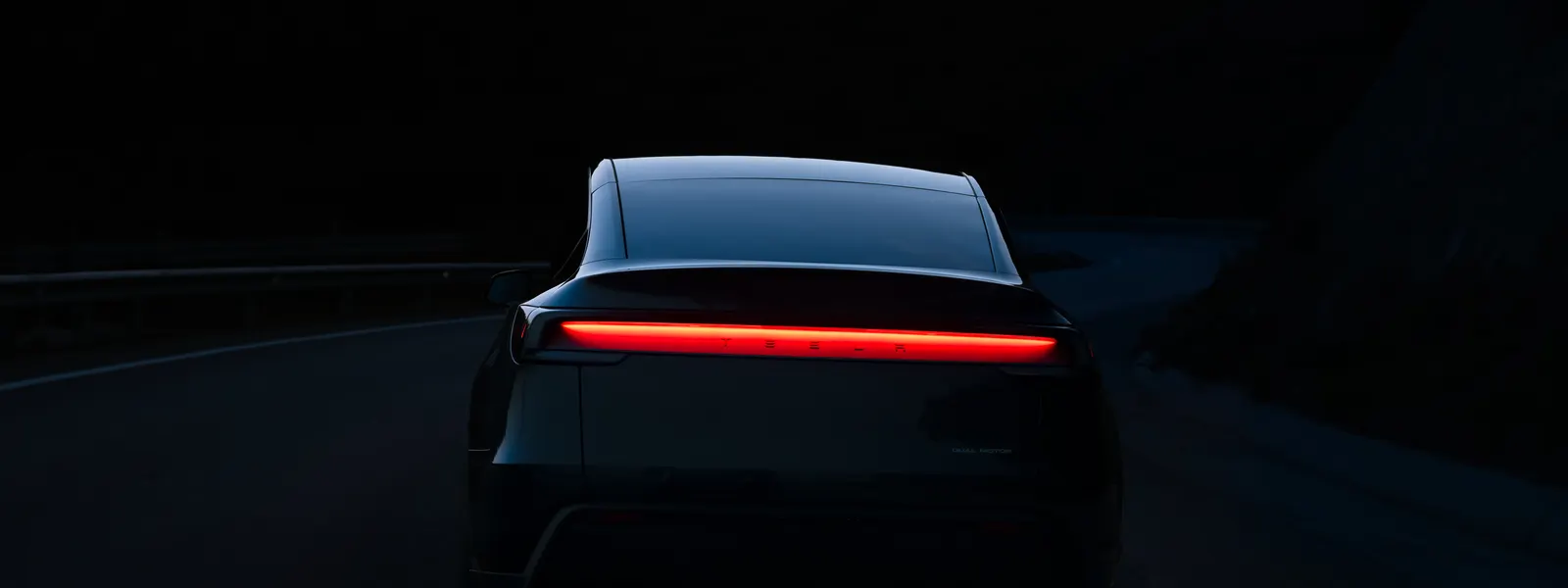 Tesla Model Y circulando al atardecer por una carretera de montaña