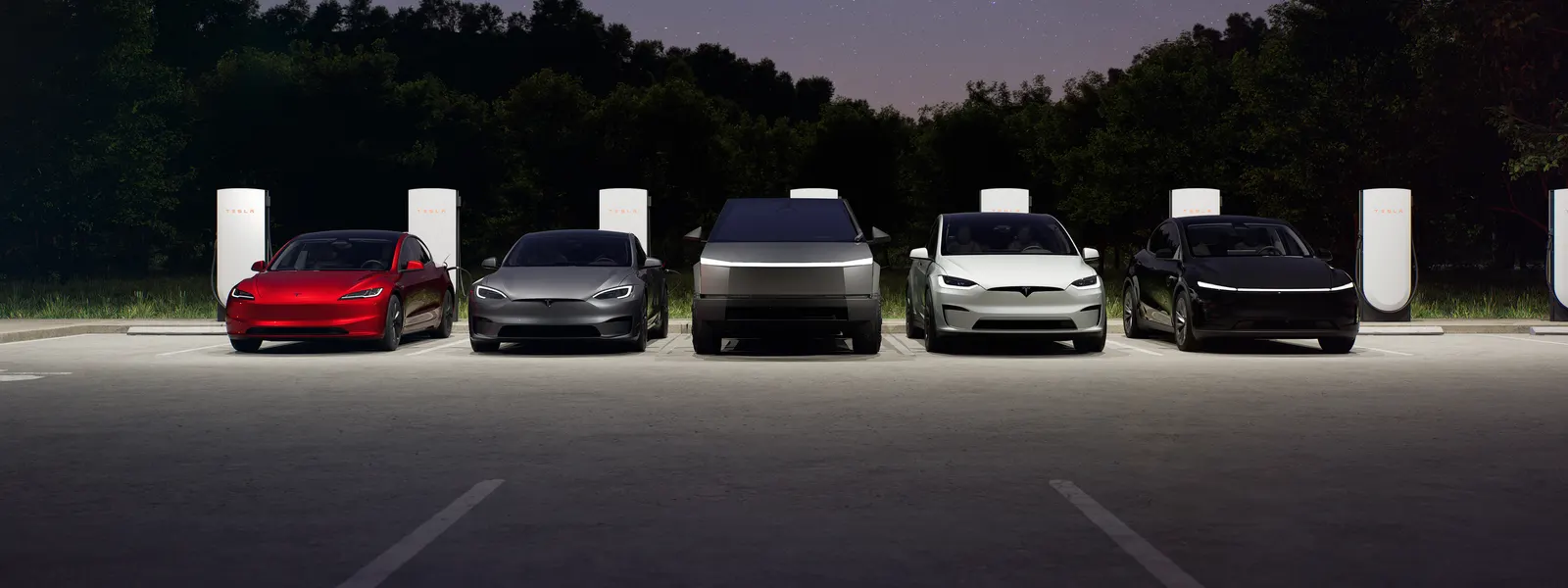Varios Tesla cargando en una estación de Supercargadores de noche